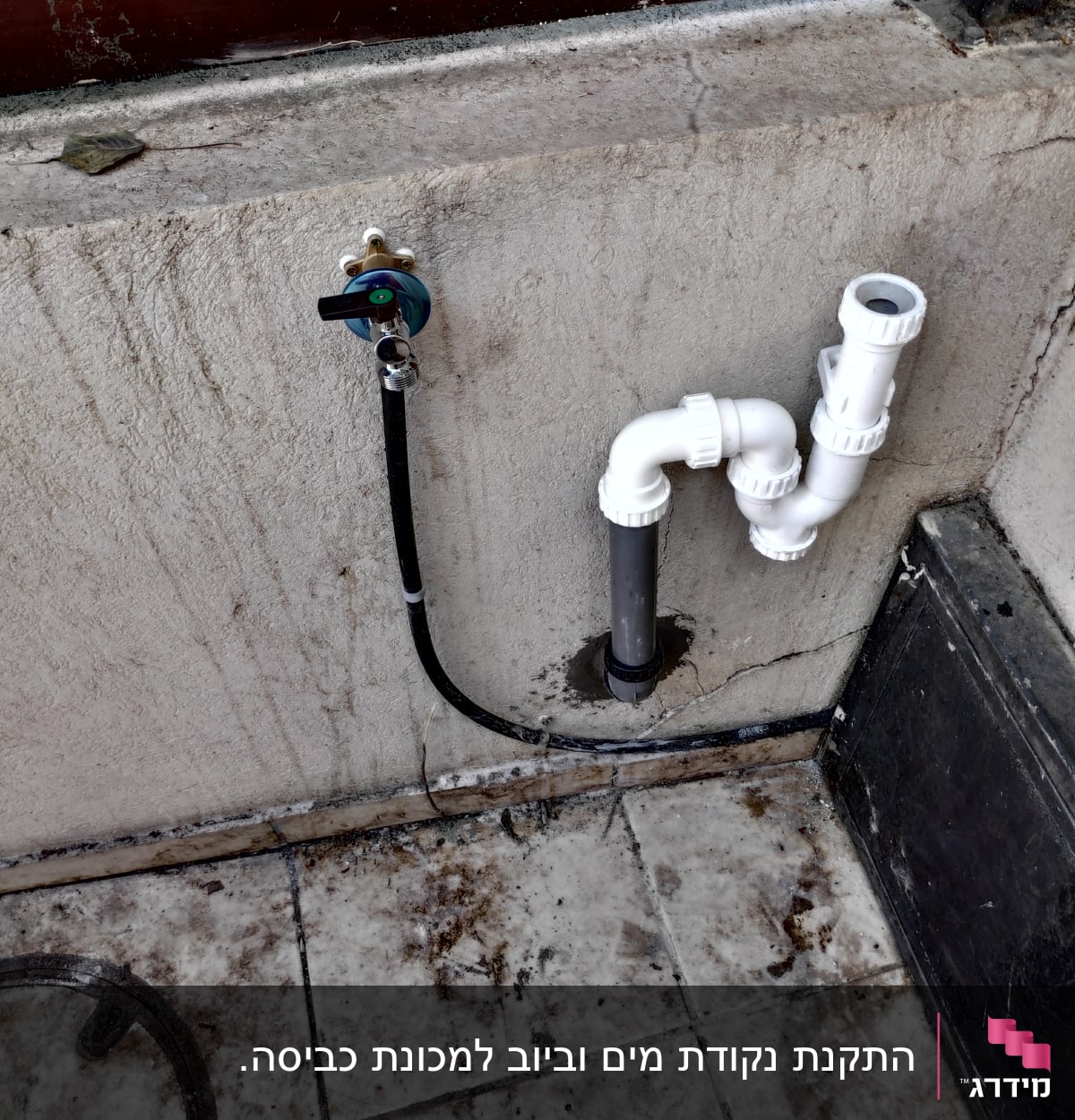 ברז מים וצינורות פלסטיק לבנים על קיר בטון